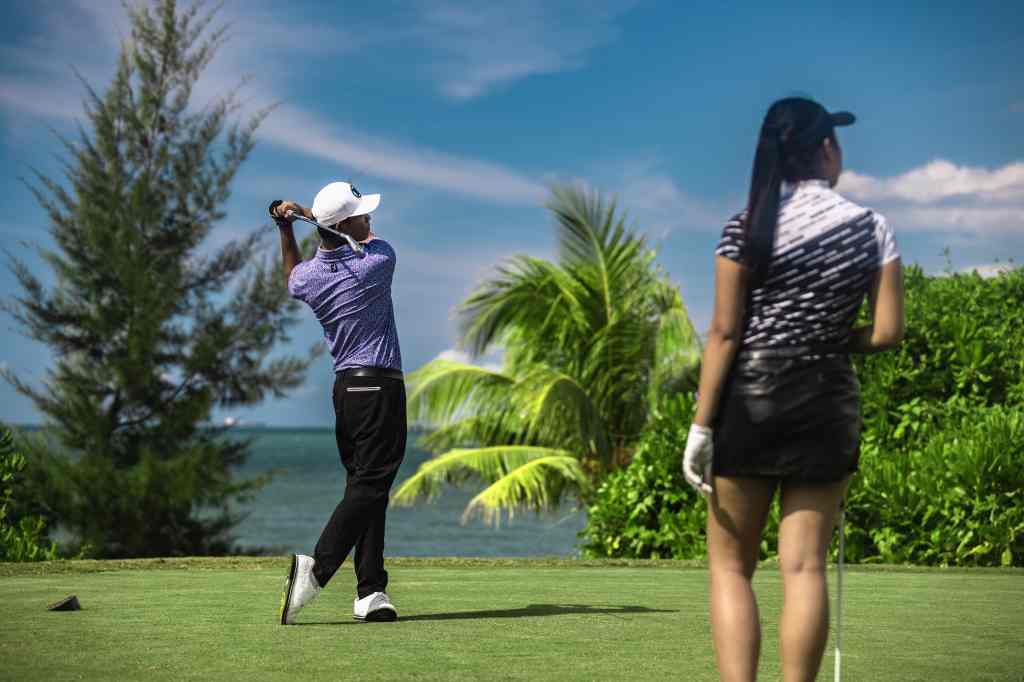 Two golfers in action on the lush green fairways of our scenic golf course, framed by beautiful landscapes and clear skies, showcasing the perfect blend of sport and nature at our premier golfing destination